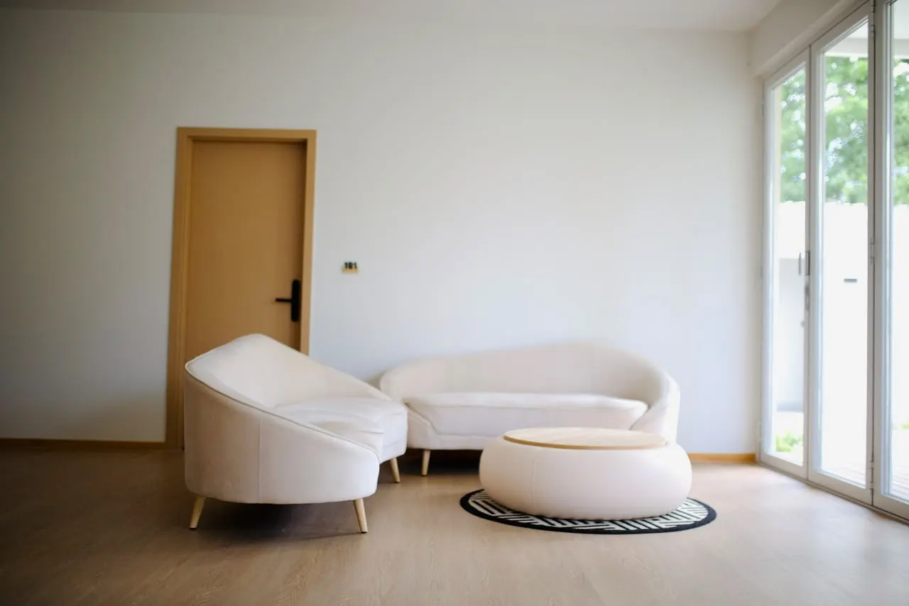 Bright lounge area with sofas and a garden door at Cozy Nest Fuvahmulah