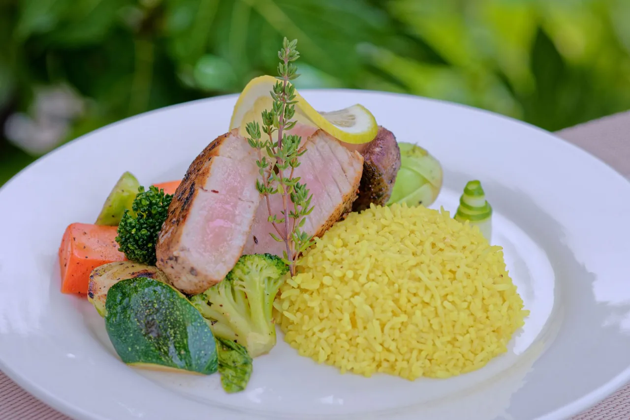 A main course of grilled fish with yellow rice and vegetables at Luau Restaurant