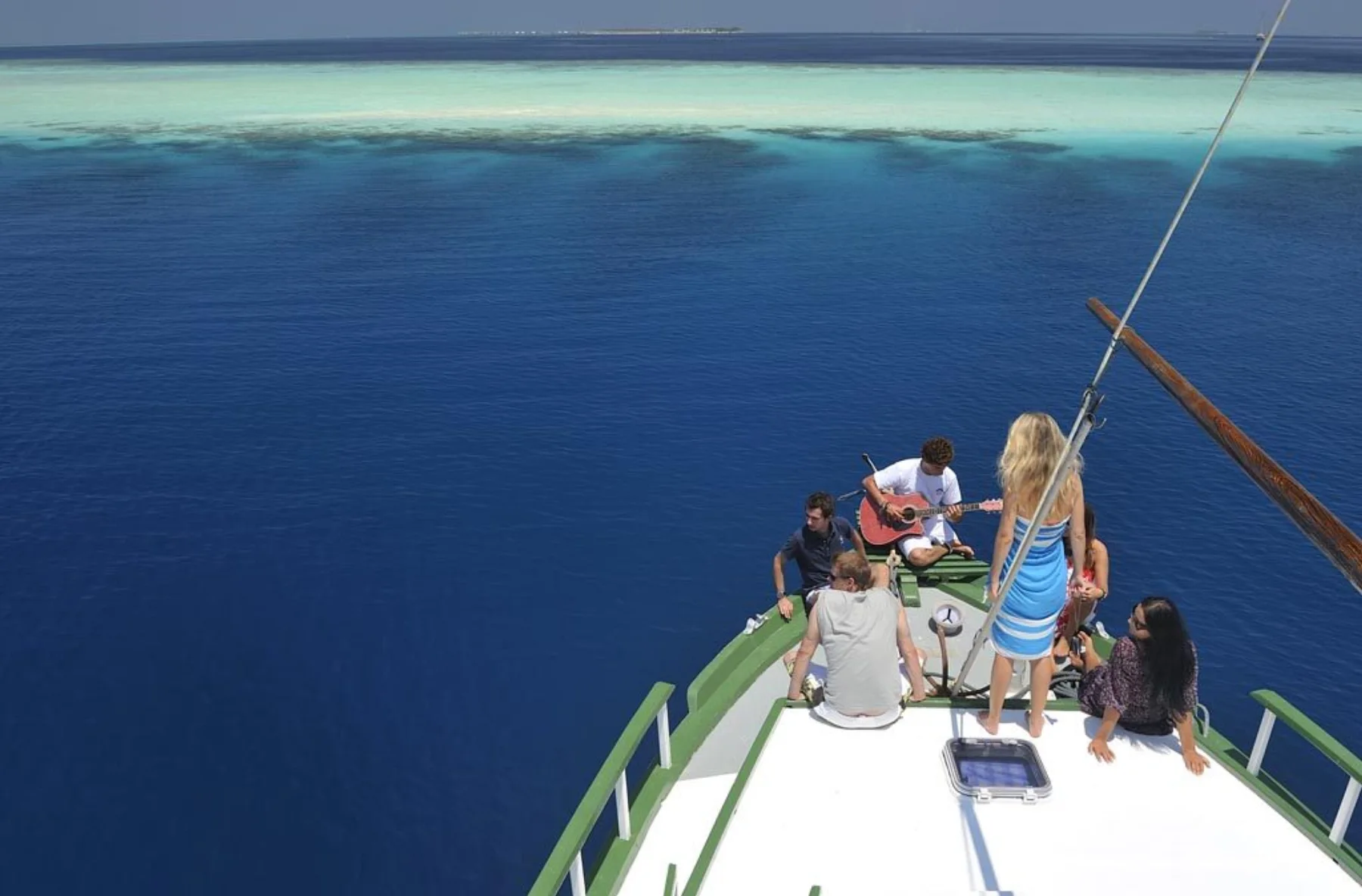 Guests relaxing on Gahaa bow deck with the Maldives ocean around them