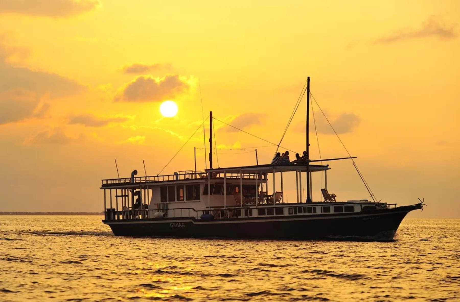 Gahaa timber safari boat shown in full against a Maldives sunset
